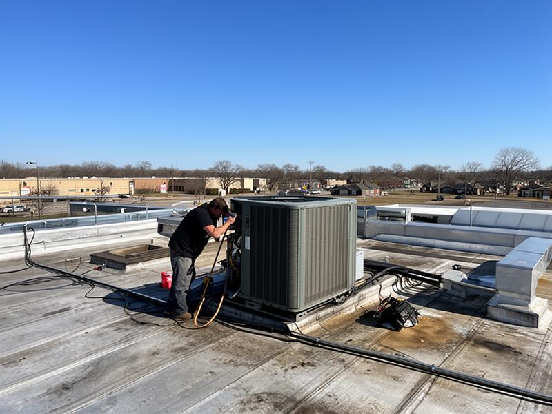 Technician servicing commercial HVAC rooftop unit